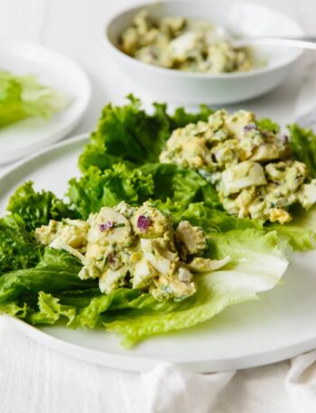 Delicious avocado egg salad over lettuce leaves.