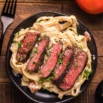 Steak fettuccine alfredo dish ready to serve and eat.